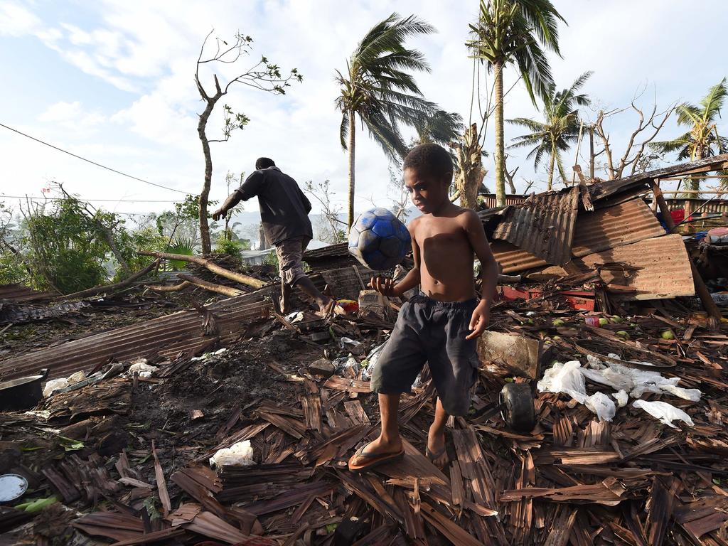 PORT VILA, VANUATU - MARCH 16:  Samuel walk through through the ruins of his family home with his father Phillip, on March 16, 2015 in Port Vila, Vanuatu. Cyclone Pam has hit South Pacific islands on Saturday with hurricane force winds, huge ocean swells and flash flooding and has caused severe damage to housing. Aid agencies say it could be one of the worst disasters ever to hit the region.  (Photo by Dave Hunt-Pool/Getty Images)