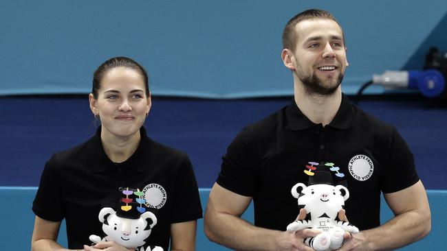 Russian athletes Anastasia Bryzgalova, left, and Alexander Krushelnitsky smile as they win accept their bronze medals for mixed doubles curling. Photo: AP