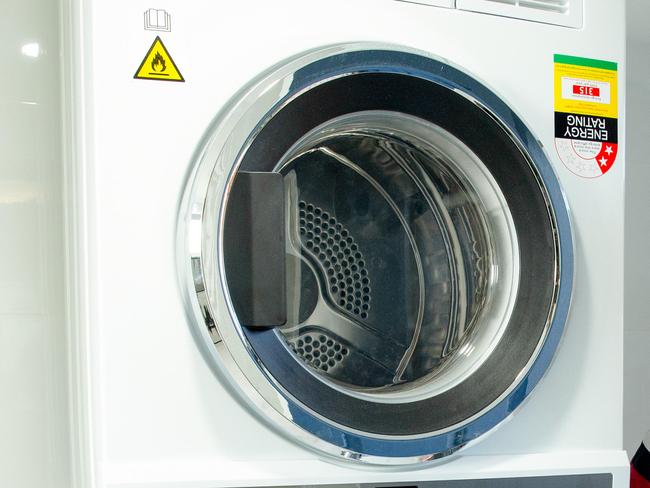 Damien Williams poses for a photograph in his Middle Park home with Fisher & Paykel washing machine and dryer, Saturday, August 24, 2019 (AAP Image/Richard Walker)