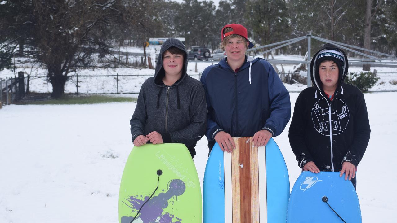 Kyle and James Garth with Hayden Riley 'boogie boarding' in the snow at Wallangarra. Photo: Alex Nolan / Stanthorpe Border Post