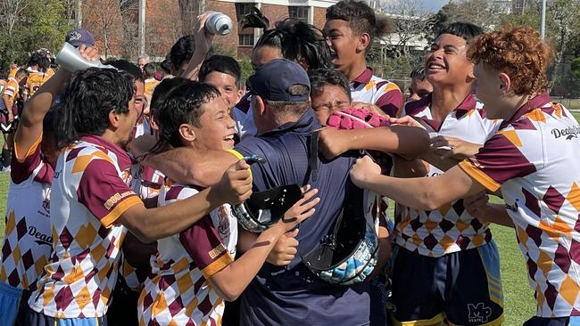 Mabel Park coach Darren Johnston is swamped by his players.