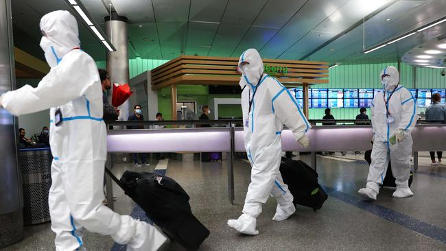 Air China flight crew members wear protective suits as they arrive at Los Angeles International Airport. Picture: AFP