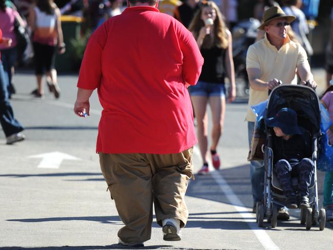 An overweight man walks through Brisbane, Monday, Aug. 12, 2013. (AAP Image/Dave Hunt) NO ARCHIVING