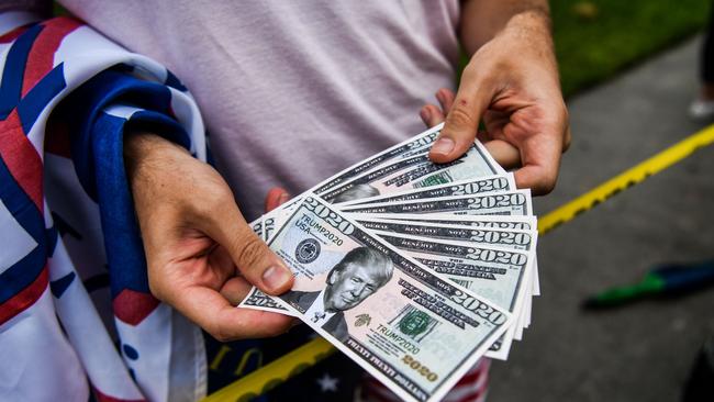 A man holds fake currency bearing the image of US President Donald Trump as he participates in a ‘Freedom Rally’ in Florida. Picture: AFP