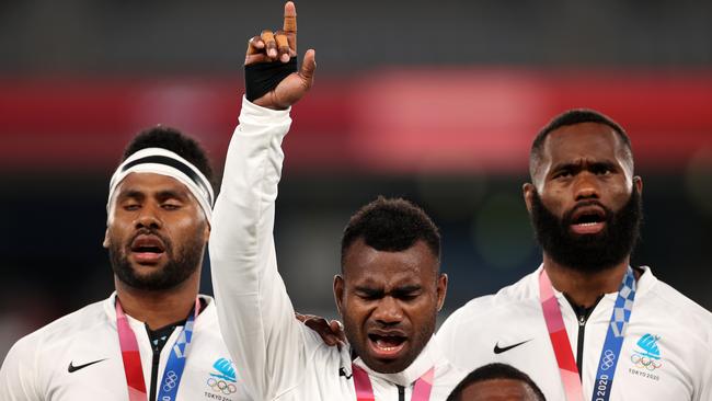 CHOFU, JAPAN - JULY 28: Jerry Tuwai of Team Fiji sings on the podium with his team mates after receiving their gold medals following victory in the Rugby Sevens Men's Gold Medal match between New Zealand and Fiji on day five of the Tokyo 2020 Olympic Games at Tokyo Stadium on July 28, 2021 in Chofu, Tokyo, Japan. (Photo by Dan Mullan/Getty Images)