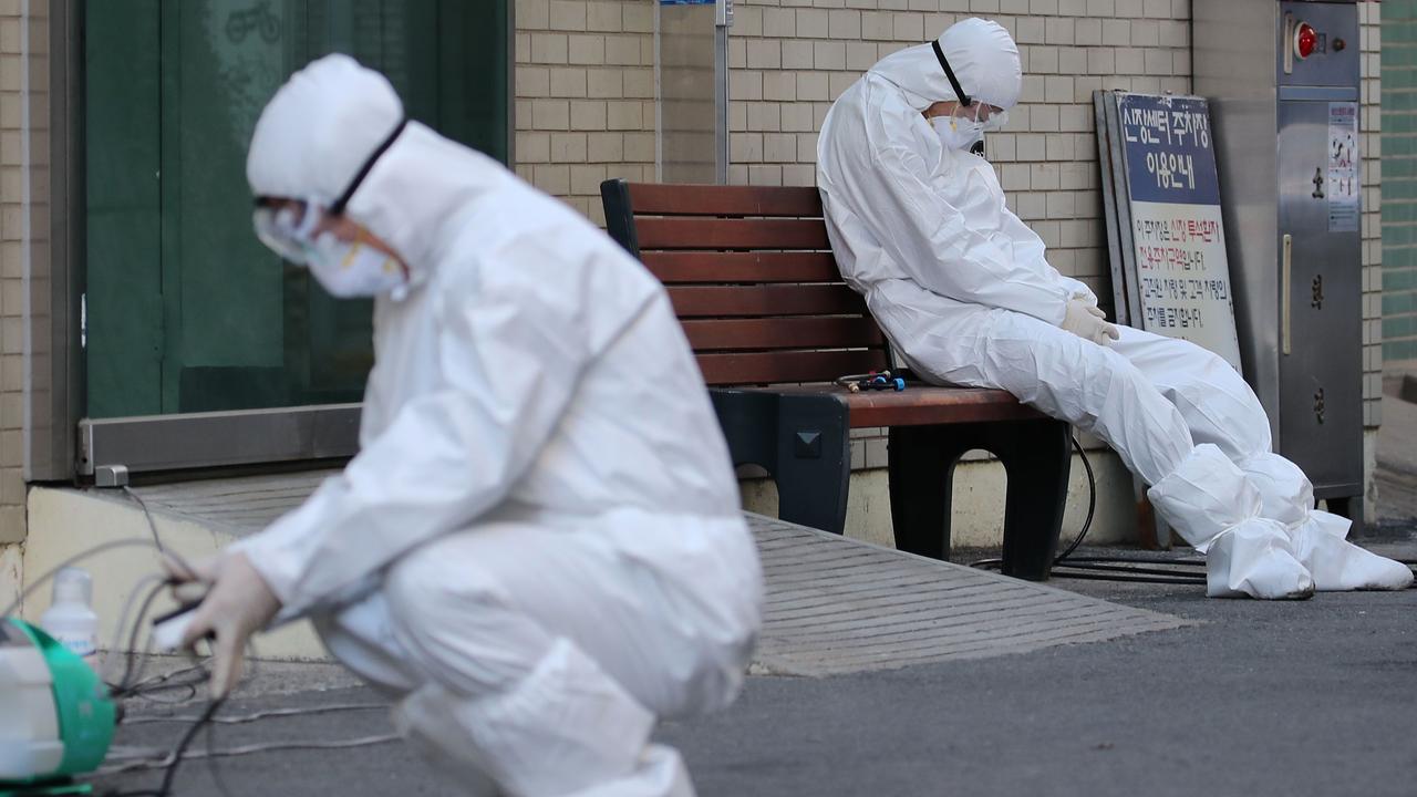 A medical worker wearing protective gear takes a rest as he waits for ambulances carrying patients infected with the COVID-19 coronavirus at an entrance of a hospital in Daegu. Picture: Yonhap/AFP