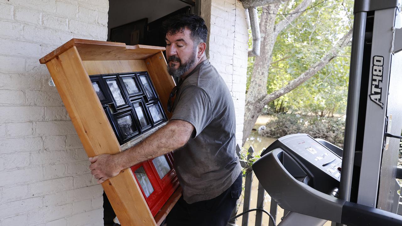 Ben Sullivan carries water-damaged things from his home in Windsor, NSW. Picture: NCA NewsWire / Dylan Coker