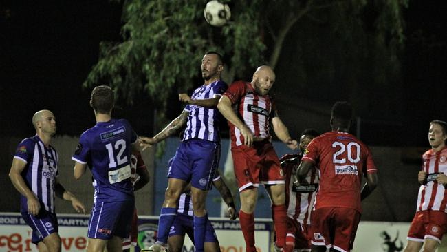 Hellenic's Savvas Trikoilis and Olympic's Mitch Amidy contest a high ball in last night's inaugural Glenti Cup match. Picture: Lou Reeve