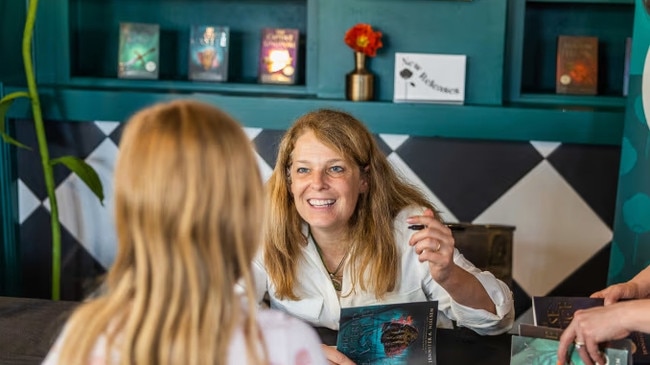 Jennifer A. Nielsen, author of bestselling World War II novels Uprising and Resistance, signs a book at a bookstore in Utah. Picture: Poppy’s Books and Gifts