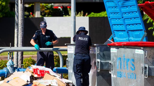 NT Police responding to an incident in Karama on Wednesday night in which an adult male was stabbed and killed. Here officers look for evidence in bins at the Karama Shopping Centre. Picture: Che Chorley