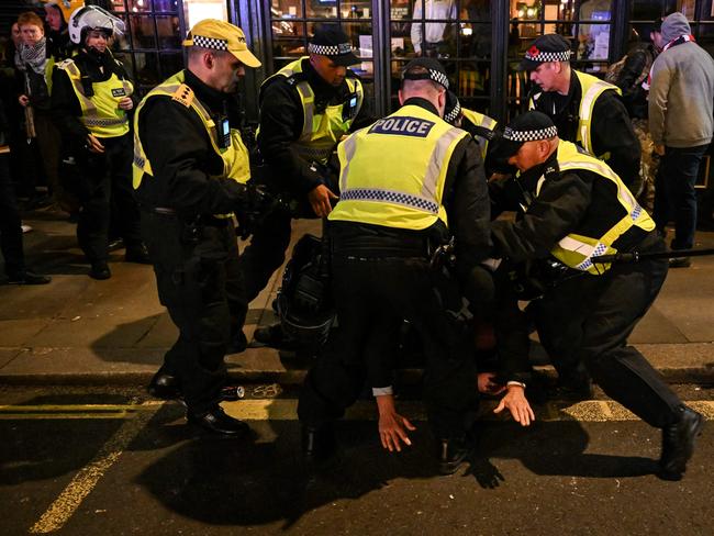 Police officers detain a man in the street by Whitehall close to the 'National March For Palestine' in central London on November 11, 2023, as counter-protest groups are monitored by police close to the route of the main march. About 300,000 people marched through the British capital, as pro-Palestinian supporters made a new call for a Gaza war ceasefire. Authorities had feared trouble as the "National March for Palestine" was scheduled for Armistice Day, Britain's annual commemoration of its war dead. Dozens of arrests were reported. Police later said that they had arrested 82 counter-protestors in order to "prevent a breach of the peace", saying they "tried to reach the main protest march. (Photo by JUSTIN TALLIS / AFP)