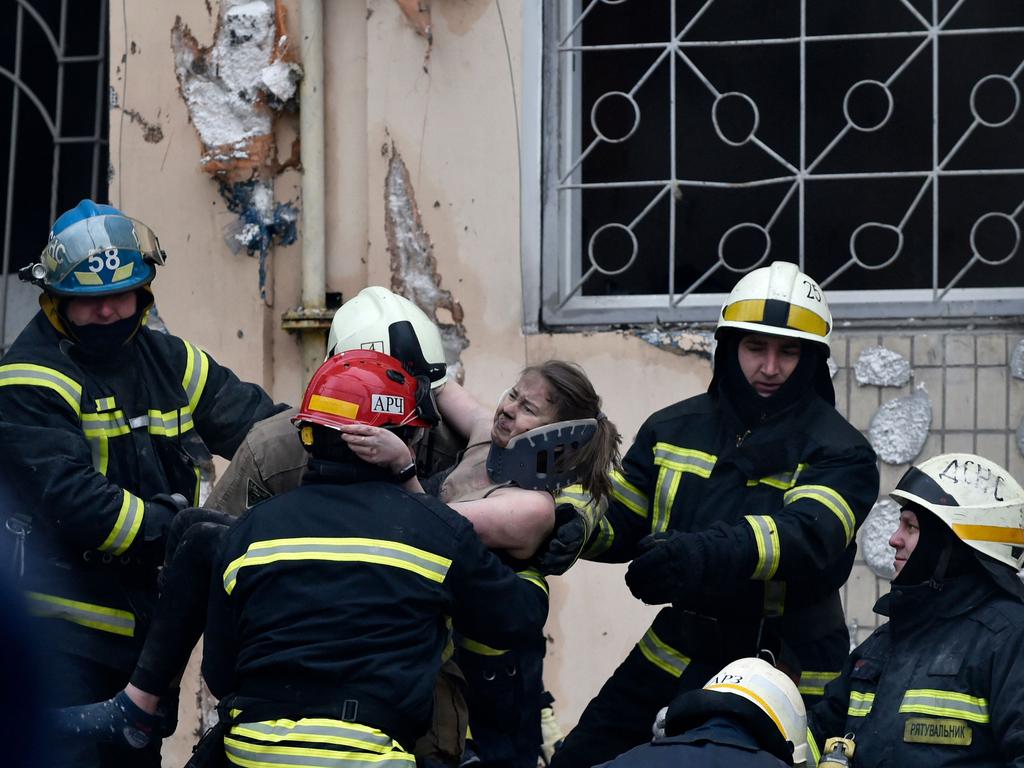 Rescuers carry a woman evacuated from the rubble of a residential building destroyed after a missile strike, in Dnipro. Picture: AFP