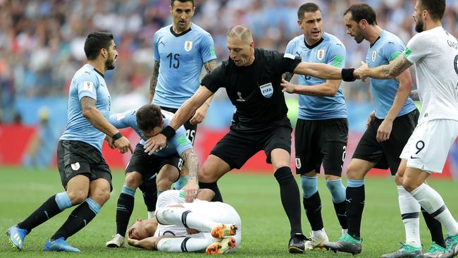 Referee Nestor Pitana stops Diego Godin, Nahitan Nandez and Luis Suarez of Uruguay from arguing with Kylian Mbappe. (Photo by Richard Heathcote/Getty Images)