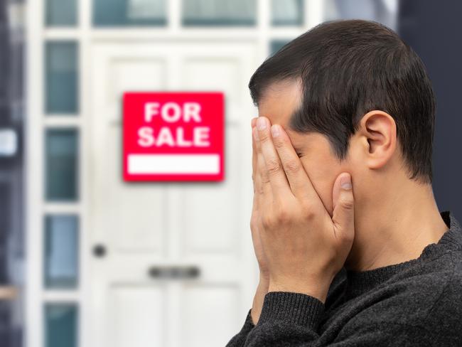 Man extremely depressed and sad about losing his house key and seeing a for sale sign, real estate concept; first home buyer generic sad, stressed