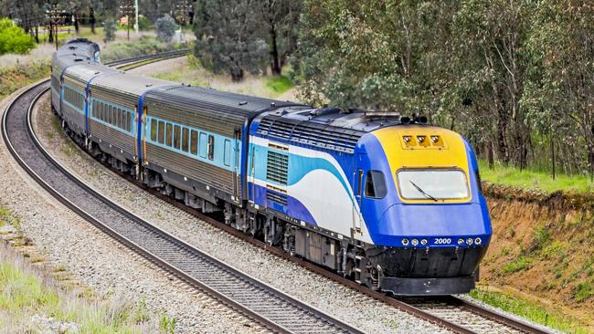 Cootamundra, Australia - Sept 30, 2016: The Countrylink XPT fast passenger train operating between Sydney & Melbourne rounds a curve in hilly rural landscape on a wet, overcast day. A High Speed Train operating between the two main Australian cities, powered by renewable energy, would replace the slow and inefficient diesel-powered service. Metaphor for cloud hanging over the future of the rail service.credit: istockescape2 may 2021kendall hill