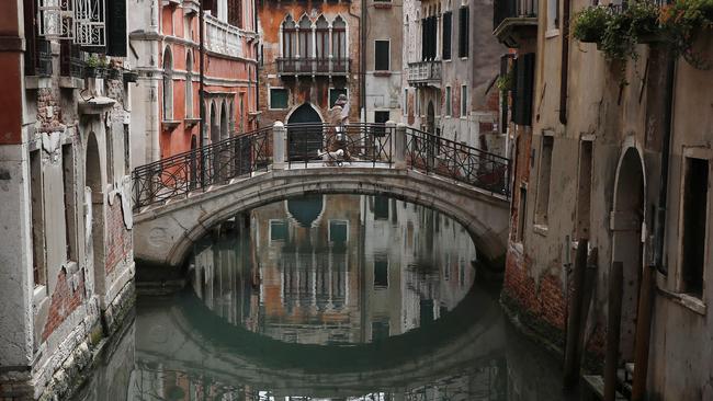 A woman walks her dog in Venice, Italy. Venetians are rethinking their city in the quiet brought by the coronavirus pandemic.