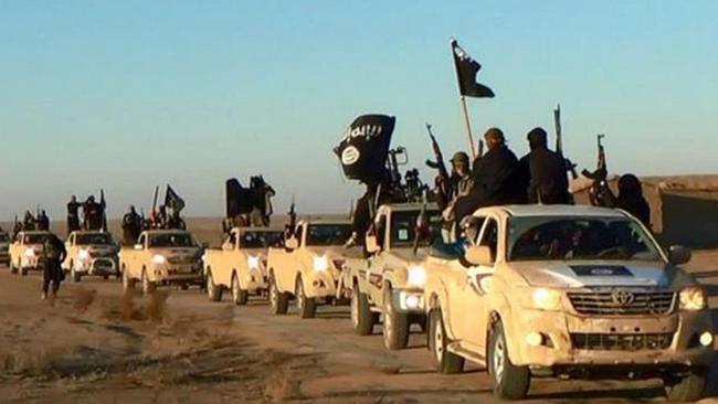 In this image released by a militant website, which has been verified, militants of the Islamic State group hold up their weapons and wave flags as they ride in a convoy through Raqqa city in Syria. Picture: AP