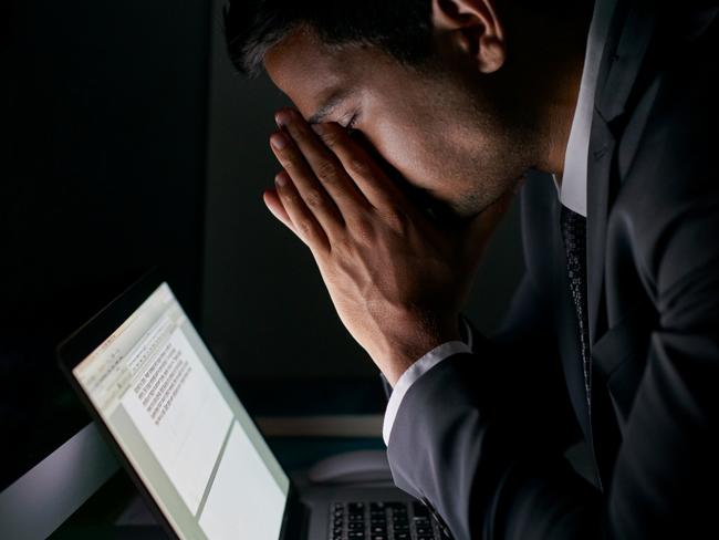 Cropped shot of a stressed out businessman working late in an officesextortion