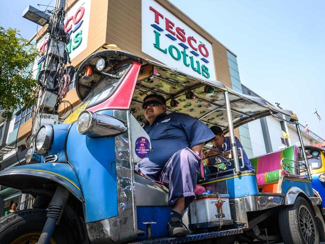 Thailand's traditional Tuk Tuk wait for customers outside a Tesco-Lotus supermarket in Bangkok on December 11, 2019 - Supermarket chain Tesco, Britain's biggest retailer, said that it was looking to sell its businesses in Thailand and Malaysia. (Photo by Mladen ANTONOV / AFP)