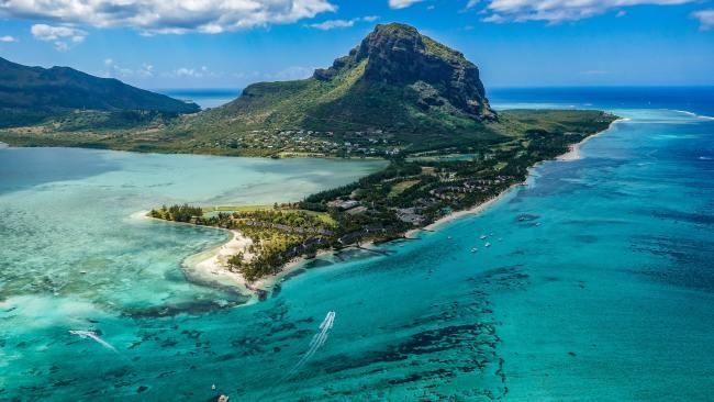 2/5Mauritius
You might think this island is all beach, but it has a lot more to offer. With five mountain ranges, Mauritius is ideal for hiking and canyoning. Its native forests are home to unique birds, lagoons and waterfalls, offering a welcomed break from your poolside punch. There’s also the Chamarel Seven Colored Earth Geopark which is an area of sand dunes of seven distinct colours. And if you’re wondering why your Ti Punch is so good (that’s a local cocktail on almost every menu), there are several rum plantations to visit as you chew on a sugar cane. 