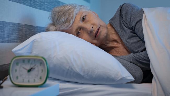 Worried senior woman in bed at night suffering from insomnia. Old woman lying in bed with open eyes. Mature woman unable to sleep at home; retirement money generic