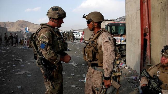 A British soldier (L) and a member of the US Armed Forces in conversation while working at Kabul Airport on August 22.