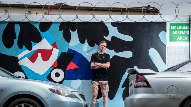 Artist Mysterious Al poses in front of his artwork at Nylex site. Picture: Jake Nowakowski