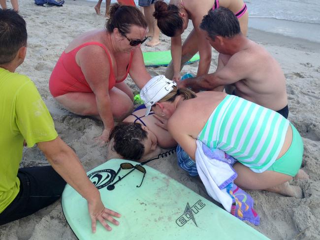 Aid ... people assist Kiersten Yow in Oak Island, North Carolina, after Sunday’s horror attack. Picture: Steve Bouser/The Pilot, Southern Pines, NC via AP