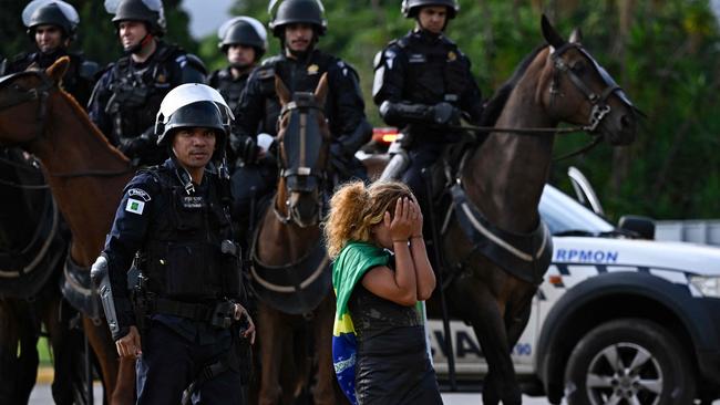 A protester is led away from the army headquarters in Brasilia. Picture: AFP