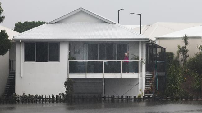 Flooding on the Gold coast in the aftermath of Cyclone Alfred. Emerald Lakes resident keeps an eye on the rising water.. Picture Glenn Hampson