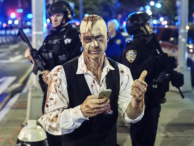 A reveler gets his picture taken by a friend in front of heavily armed police during the Greenwich Village Halloween Parade. Picture: AP