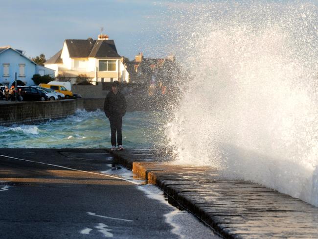 Children walk along the seawall in Ile-Tudy on Combrit, western France during high tide. The exceptionally high spring tide has been swollen by a "supermoon" effect linked to the solar eclipse on March 20. Picture: AFP/FRED TANNEAU