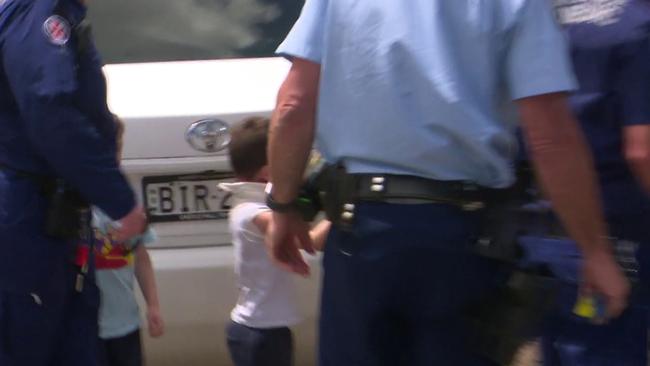 Paramedics and police escort the boy to an ambulance following the attack. Picture: TNV