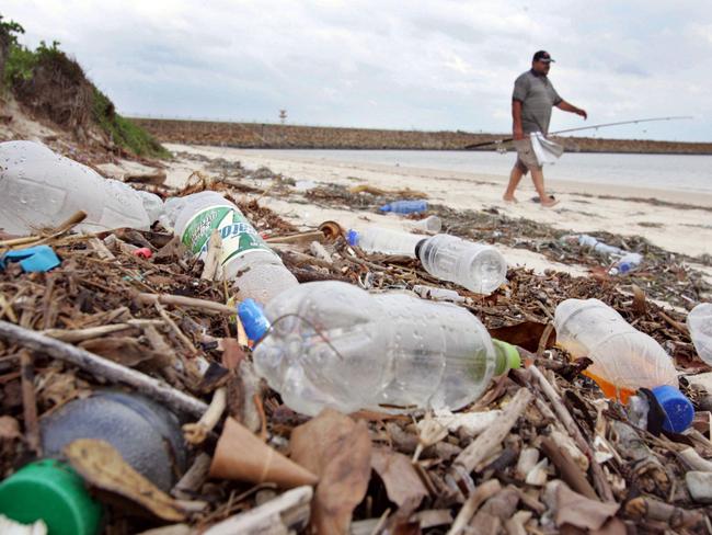 A fisherman walks along a plastic-polluted beach in Sydney. File picture.