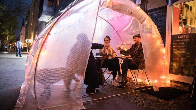 Guests sit in a greenhouse at a coffee shop and bar in Berlin. Picture: AFP