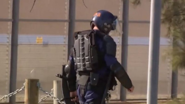 Police in riot helmets and shields enter the Yatala Prison at Northfield. Picture: 7NEWS