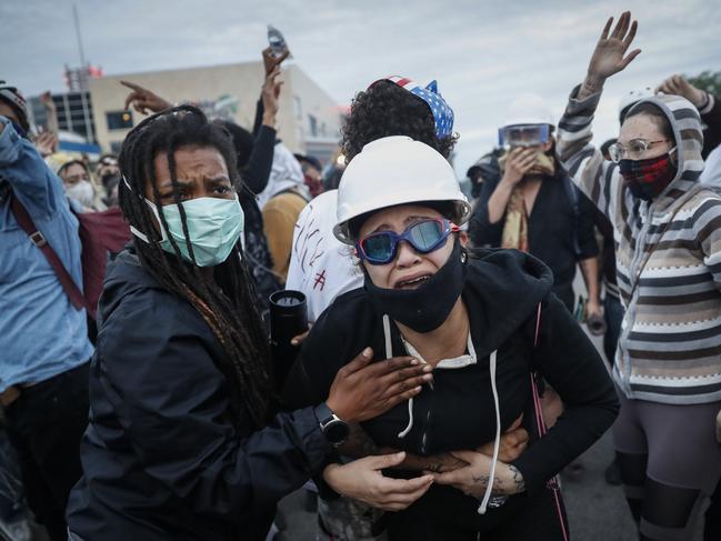 A protester reacts after being hit by crowd dispersal rounds as a group of demonstrators are detained prior to arrest in Minneapolis. Picture: AP