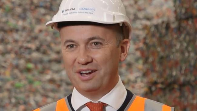 Environment minister Matt Kean talks up the return and earn scheme in front of mountains of recyclable plastic.