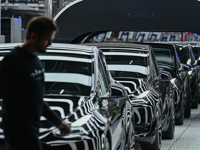 (FILES) A line of electric vehicles of the model Y is pictured during the start of the production at Tesla's "Gigafactory" plant on March 22, 2022 in Gruenheide, southeast of Berlin. Tesla halted production at its German factory on March 5, 2024 after assailants allegedly set fire to high-voltage lines nearby, cutting power to the US electric carmaker's only plant in Europe, the company and authorities said. (Photo by Patrick Pleul / POOL / AFP)