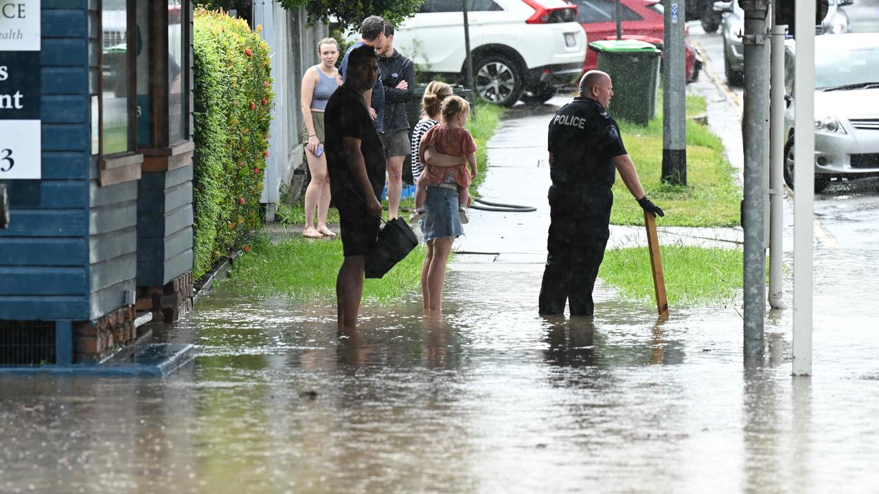 Police and residents in ankle deep water at Stones Corner. Lyndon Mechielsen/Courier Mail