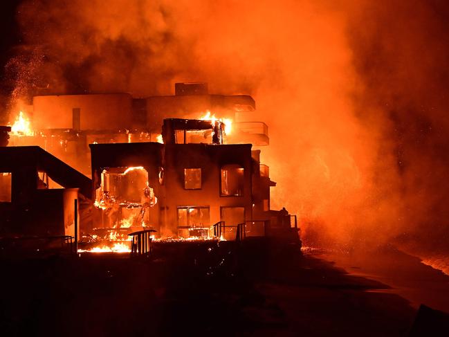 TOPSHOT - A beach house is engulfed in flames as the Palisades Fire burns along Pacific Coast Highway in Malibu, California, on January 8, 2025. At least five people have been killed in wildfires rampaging around Los Angeles, officials said on January 8, with firefighters overwhelmed by the speed and ferocity of multiple blazes -- including in Hollywood. (Photo by AGUSTIN PAULLIER / AFP)