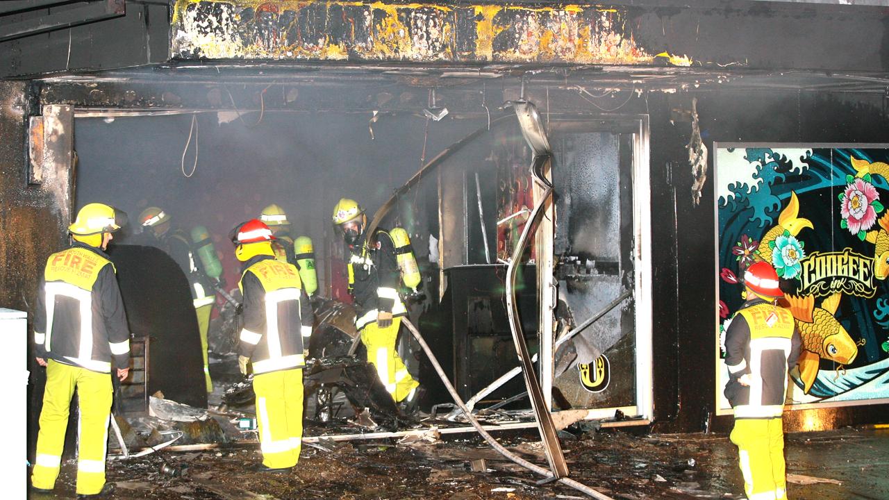 Firemen extinguish the blaze at Coogee Ink tattoo parlour after it was bombed in an attack.