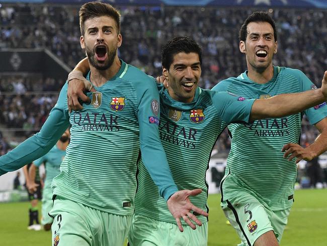 Barcelona's Gerard Pique, left, celebrates with his teammates Luis Suarez and Sergio Busquets.