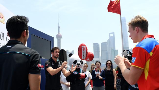 Gold Coast Suns co-captain Tom Lynch (right) and Port captain Travis Boak demonstrate how to hand ball pass at a press conference in Shanghai, China. Picture: AAP Image/Tracey Nearmy