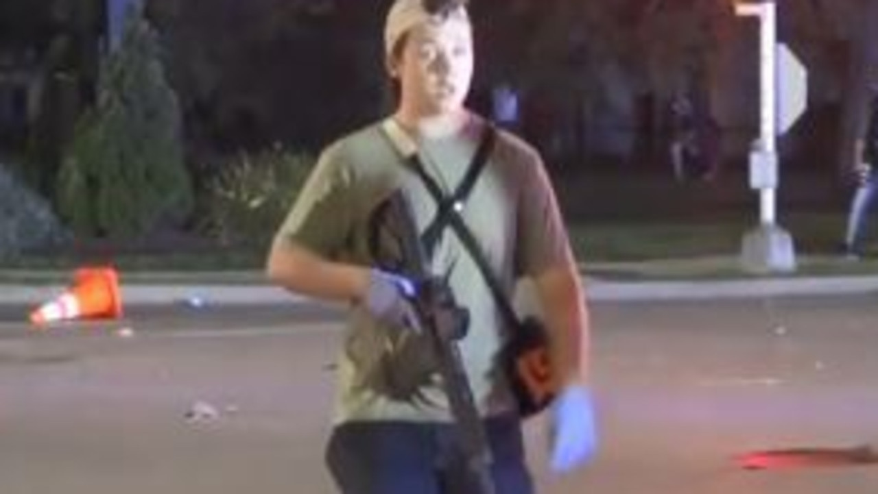 US teen shooter Kyle Rittenhouse walks down a Kenosha street with a rifle.