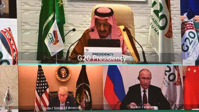 Saudi King Salman bin Abdulaziz gives an address opening the G20 summit, while below him are outgoing US President Donald Trump and Russian President Vladimir Putin. Picture: AFP