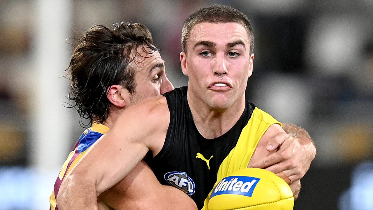 Jack Ross of the Tigers is pressured by Rhys Mathieson of the Lions. Picture: Bradley Kanaris