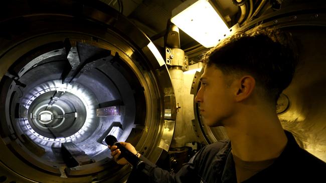 US navy Officer Devin Simpson inspects the shoot where torpedoes fired from the USS Minnesota. Picture: NewsWire/Pool/ Colin Murty