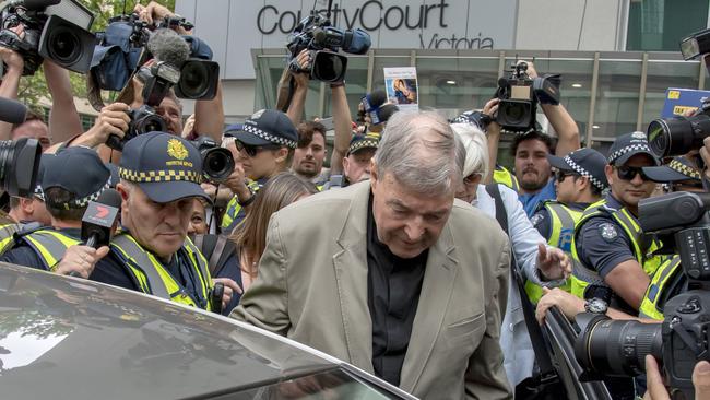 The suppression order was lifted in court today. Media and police surround Cardinal George Pell outside court today. Picture: AP 