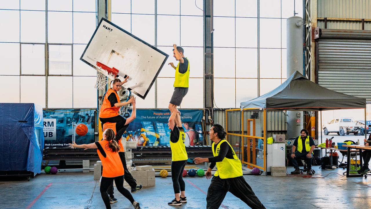 Students try to score against a moving basketball hoop controlled by a robotic arm at the Advanced Robotics for Manufacturing Hub.